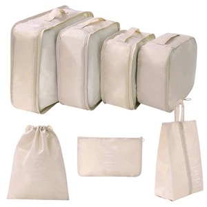 Beige 7-piece travel organizer set with mesh packing cubes and drawstring laundry bags