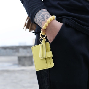 Detail of yellow silicone beaded wristlet with matching PU leather card holder and tassel