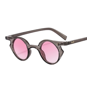 Punk style sunglasses with gray transparent frame and round pink lenses at 45-degree angle