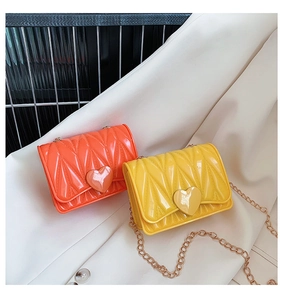 Detail of vibrant silicone heart bags with geometric V-texture and gold chain straps