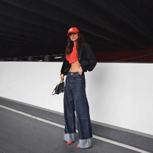Tenue femme avec jean large évasé, crop top rouge et veste noire élégante