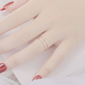 Minimalist stackable rose gold titanium rings on model hand with elegant white veil backdrop