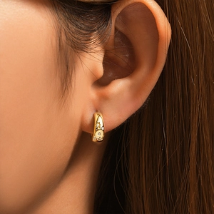 Macro shot of 18K gold plated silver C-shaped star hoop earrings with sparkling cubic zirconia