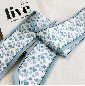 Detail of blue floral skinny silk scarf twilly made of premium polyester fabric