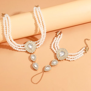 Detail of double-layer pearl anklets with golden rhinestone pendants in a two-piece set
