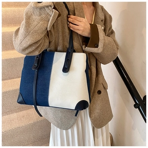 Detail of blue and white denim tote bag with leather straps on lifestyle stairs