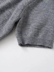 Detailed macro view of the premium grey knit fabric and ribbed cuffs on the top