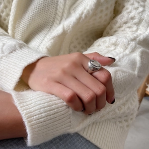 Detail of 925 sterling silver vintage oval ring worn on hand with cozy knit sweater