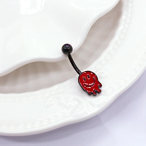 Gros plan d'un piercing de nombril à smiley rouge sur une plaque en céramique blanche