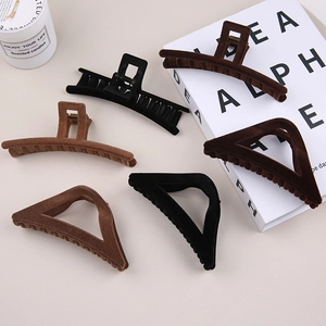 Close-up of matte flocked hair claw clips in black and brown colors for autumn