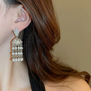 Gros plan de boucles d'oreilles à pompons en perles vintage avec strass sur mannequin