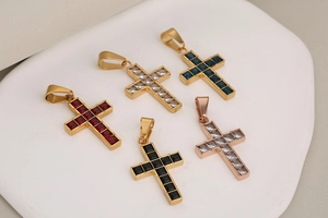 Macro view of five luxury hip-hop cross pendants with colorful square-cut rhinestones