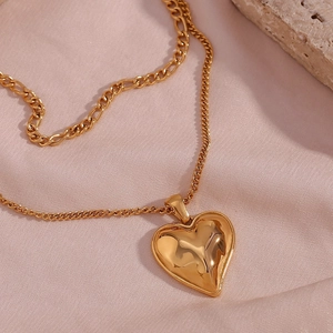 Detail of 18K gold plated heart pendant necklace with wavy texture on silk background