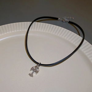 Detail of gothic faux leather choker featuring an engraved silver cross pendant