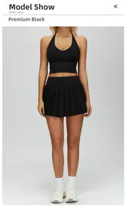 Detail of high-waist pleated tennis skirt and halter neck sports top in black