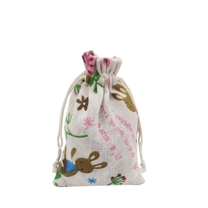 Detail of beige cotton drawstring bag with cartoon rabbit and floral plant prints