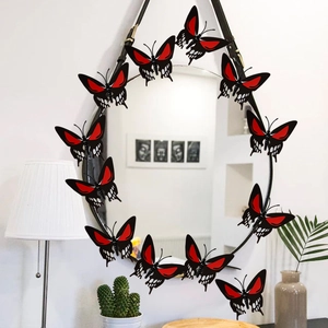 Black and red 3D butterfly wall stickers arranged around a mirror in a cozy living room