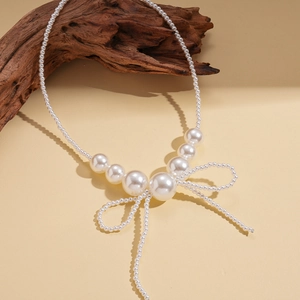 Baroque style faux pearl necklace featuring a large woven bow pendant and elegant design