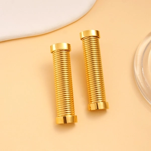 Macro detail of 18K gold-plated stainless steel earrings with spring-like spiral texture