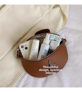 Detail showing spacious interior of brown crossbody bag with silver star buckle