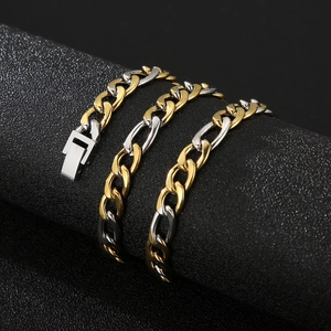 Close-up of two-tone gold and silver Figaro chain link bracelet on a textured background