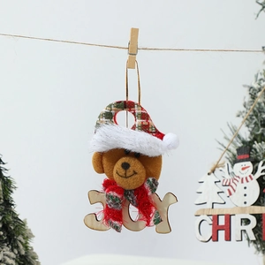 Gros plan d'un ours de Noël en peluche avec lettrage JOY en bois sur une corde de fête