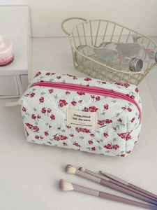 Macro detail of floral corduroy makeup bag with quilted texture and pink zipper closure