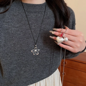 Detail of hollow five-petal flower necklace and frosted heart pendant with red beads