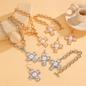 Macro view of textured spiral cross jewelry set with pearls on necklace and bracelet