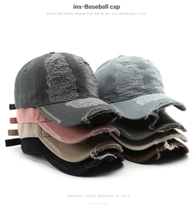 Detail showing various colors of distressed cotton baseball caps with vintage fraying
