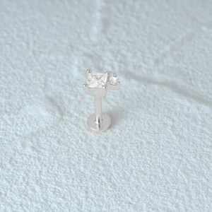 Macro shot of silver labret stud with square princess cut and round clear gemstones