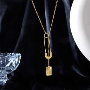 Golden chain necklace with safety pin pendant and Love engraved rectangular tag