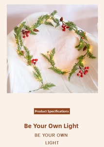 Detail of Christmas garland with red berries, pine cones and warm LED string lights