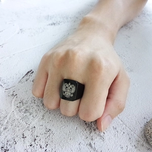 Close-up of black matte signet ring for men featuring an engraved double-headed eagle design