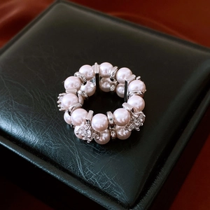 Macro shot of double-layer pearl elastic ring with crystal spacers on black leather box