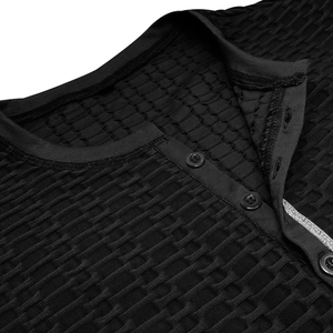 Gros plan sur le tissu gaufré noir et le col à trois boutons du t-shirt Henley homme