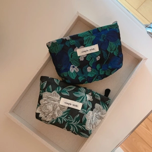Detail of floral jacquard mini pouches with zipper closure and simple wish fabric label