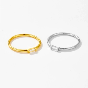 Detail shot of gold and silver minimalist rings with rectangular zircon on white background