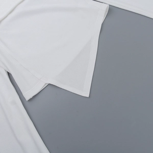 Detail of white ribbed knit fabric with asymmetric hem design on a slim-fit top