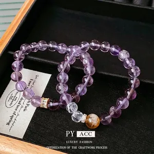 Elegant purple amethyst and yellow crystal beaded bracelets on black jewelry display