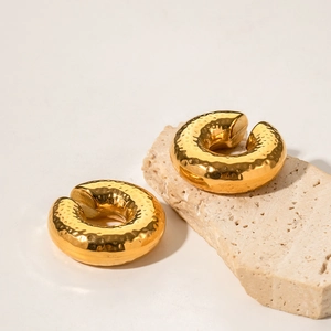Close-up of 18K gold plated stainless steel hoop earrings with hammered metal texture