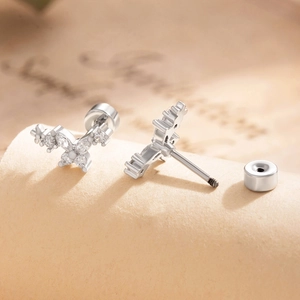 Silver flower screw back earrings with sparkling zircons on textured vintage paper
