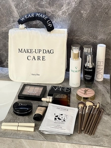 Detail view of a large white travel makeup bag with a pearl handle and high storage capacity