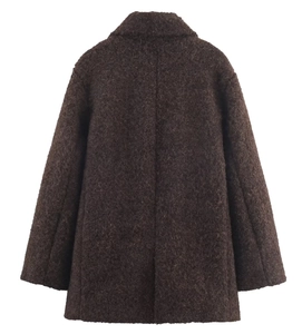 Detail of dark brown boucle wool fabric texture on the back of a long sleeve coat