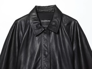 Détail de la veste en cuir noir de haute qualité montrant l'étiquette et la texture fine