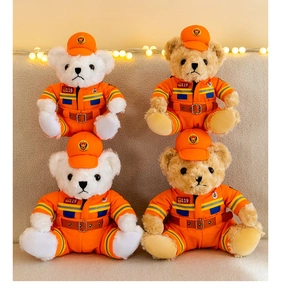 Close-up of four plush teddy bears in orange firefighter uniforms with 119 badges.