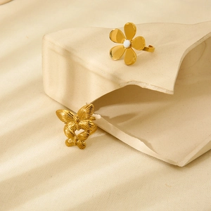 Gros plan sur des bagues en acier inoxydable plaqué or 18 carats, fleurs et papillons