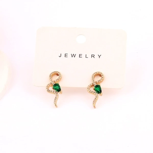 Detail of snake earrings in gold plating with green drop-shaped zircons on display card