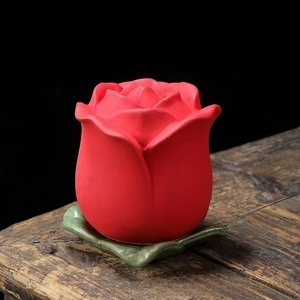 Vista dettagliata di una rosa rossa in ceramica su una base a forma di foglia verde
