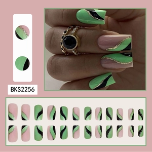 Detail of pink and green press-on nails with black wavy lines and gold glitter finish